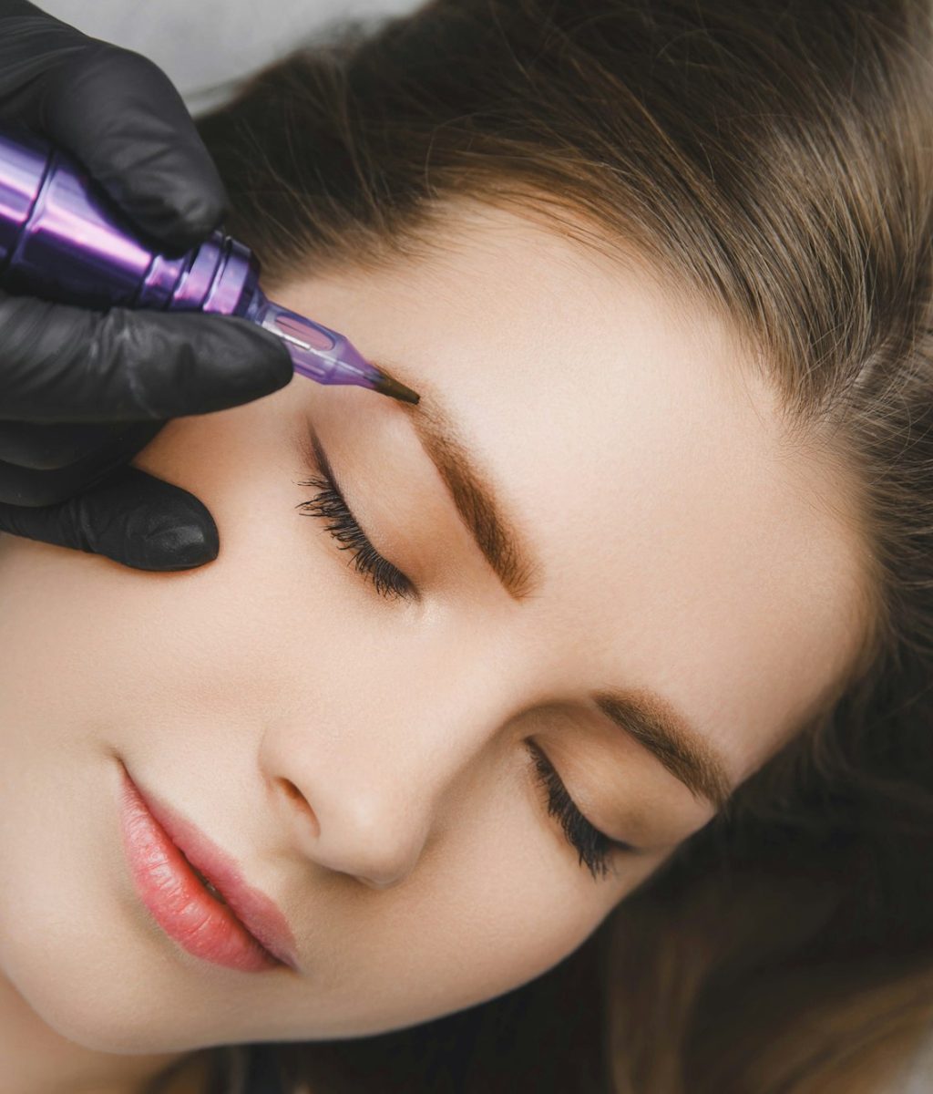 A cosmetologist applies permanent makeup to the eyebrows - eyebrow tattoo. eyebrow perm